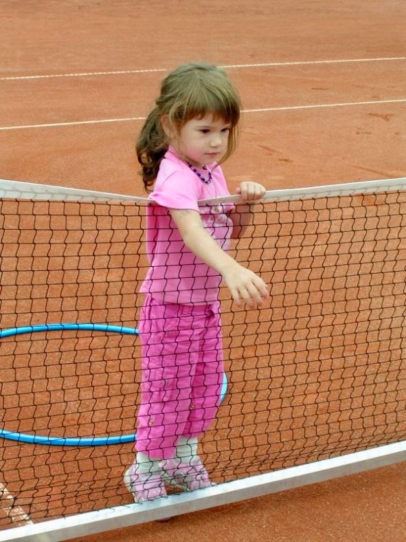 Zoe Kägi als Kleinkind am Tennisnetz